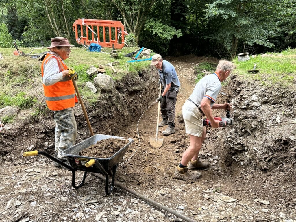 Three volunteers working on a railway culvert